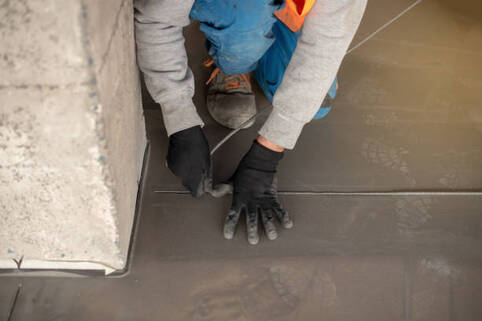 Person measuring the floor for an epoxy coating installation in Norwalk.
