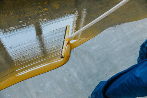 Yellow epoxy being installed with a squeegee.