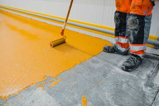 Person installing yellow epoxy flooring at a commercial location in Norwalk.
